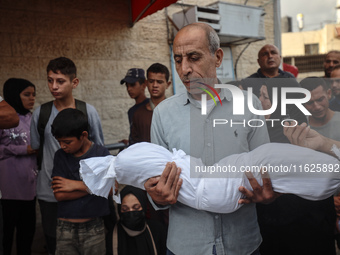 Relatives of Palestinians who are killed following the Israeli attack on the Nuseirat refugee camp mourn after the bodies are transferred to...