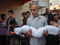 Relatives of Palestinians who are killed following the Israeli attack on the Nuseirat refugee camp mourn after the bodies are transferred to...