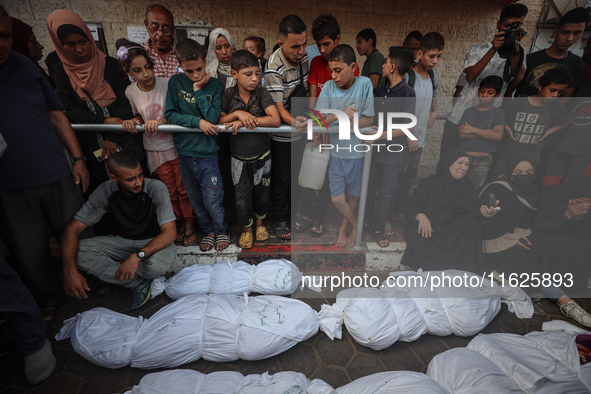 Relatives of Palestinians who are killed following the Israeli attack on the Nuseirat refugee camp mourn after the bodies are transferred to...