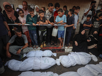 Relatives of Palestinians who are killed following the Israeli attack on the Nuseirat refugee camp mourn after the bodies are transferred to...