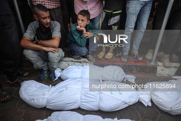 Relatives of Palestinians who are killed following the Israeli attack on the Nuseirat refugee camp mourn after the bodies are transferred to...