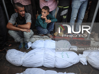 Relatives of Palestinians who are killed following the Israeli attack on the Nuseirat refugee camp mourn after the bodies are transferred to...