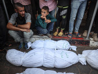 Relatives of Palestinians who are killed following the Israeli attack on the Nuseirat refugee camp mourn after the bodies are transferred to...