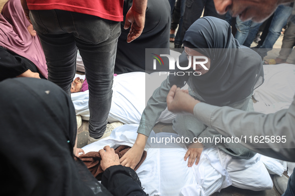 Relatives of Palestinians who are killed following the Israeli attack on the Nuseirat refugee camp mourn after the bodies are transferred to...