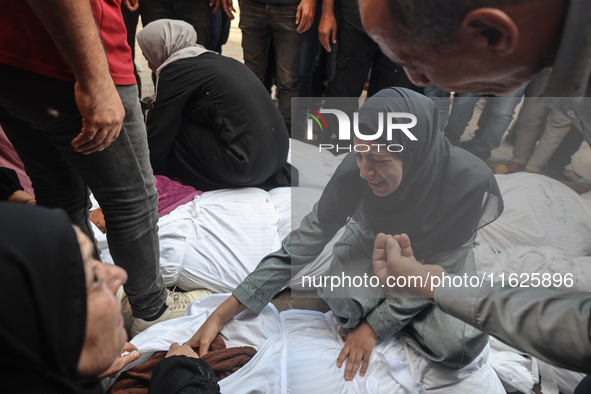 Relatives of Palestinians who are killed following the Israeli attack on the Nuseirat refugee camp mourn after the bodies are transferred to...