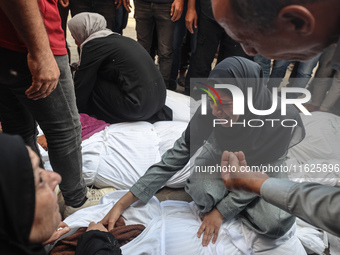 Relatives of Palestinians who are killed following the Israeli attack on the Nuseirat refugee camp mourn after the bodies are transferred to...