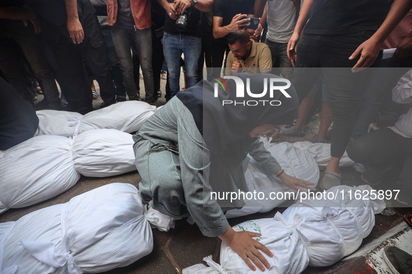 Relatives of Palestinians who are killed following the Israeli attack on the Nuseirat refugee camp mourn after the bodies are transferred to...