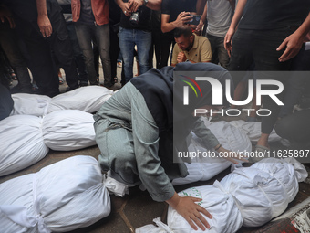 Relatives of Palestinians who are killed following the Israeli attack on the Nuseirat refugee camp mourn after the bodies are transferred to...