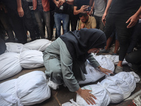 Relatives of Palestinians who are killed following the Israeli attack on the Nuseirat refugee camp mourn after the bodies are transferred to...