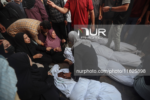 Relatives of Palestinians who are killed following the Israeli attack on the Nuseirat refugee camp mourn after the bodies are transferred to...