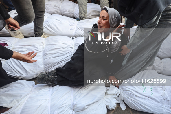 Relatives of Palestinians who are killed following the Israeli attack on the Nuseirat refugee camp mourn after the bodies are transferred to...