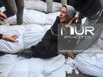 Relatives of Palestinians who are killed following the Israeli attack on the Nuseirat refugee camp mourn after the bodies are transferred to...