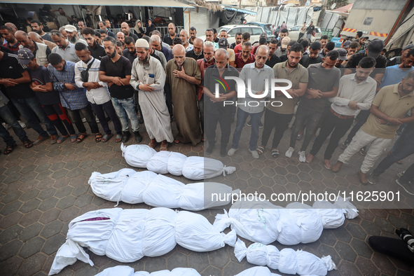 Relatives of Palestinians who are killed following the Israeli attack on the Nuseirat refugee camp mourn after the bodies are transferred to...