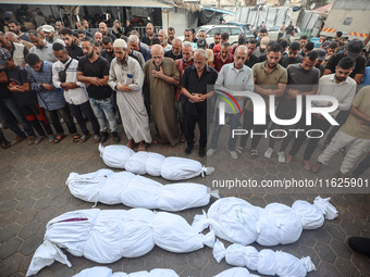 Relatives of Palestinians who are killed following the Israeli attack on the Nuseirat refugee camp mourn after the bodies are transferred to...