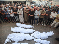 Relatives of Palestinians who are killed following the Israeli attack on the Nuseirat refugee camp mourn after the bodies are transferred to...