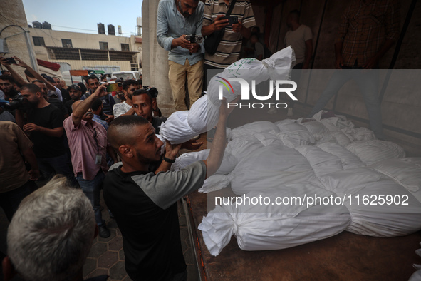 Relatives of Palestinians who are killed following the Israeli attack on the Nuseirat refugee camp mourn after the bodies are transferred to...