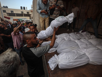 Relatives of Palestinians who are killed following the Israeli attack on the Nuseirat refugee camp mourn after the bodies are transferred to...