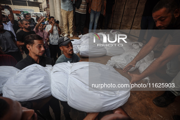 Relatives of Palestinians who are killed following the Israeli attack on the Nuseirat refugee camp mourn after the bodies are transferred to...