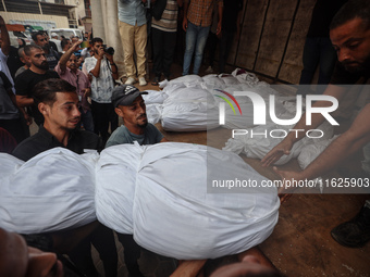 Relatives of Palestinians who are killed following the Israeli attack on the Nuseirat refugee camp mourn after the bodies are transferred to...