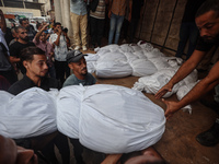 Relatives of Palestinians who are killed following the Israeli attack on the Nuseirat refugee camp mourn after the bodies are transferred to...