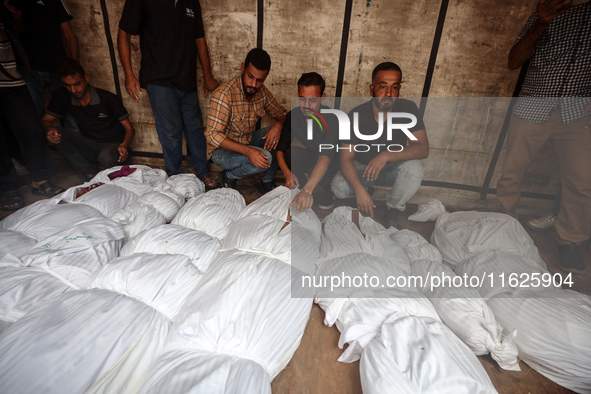 Relatives of Palestinians who are killed following the Israeli attack on the Nuseirat refugee camp mourn after the bodies are transferred to...