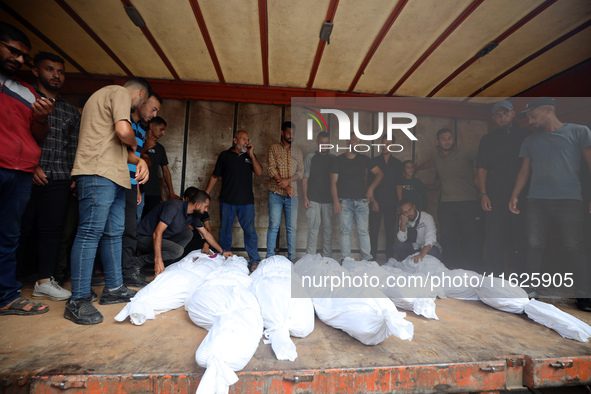 Relatives of Palestinians who are killed following the Israeli attack on the Nuseirat refugee camp mourn after the bodies are transferred to...