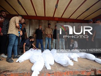 Relatives of Palestinians who are killed following the Israeli attack on the Nuseirat refugee camp mourn after the bodies are transferred to...