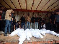 Relatives of Palestinians who are killed following the Israeli attack on the Nuseirat refugee camp mourn after the bodies are transferred to...