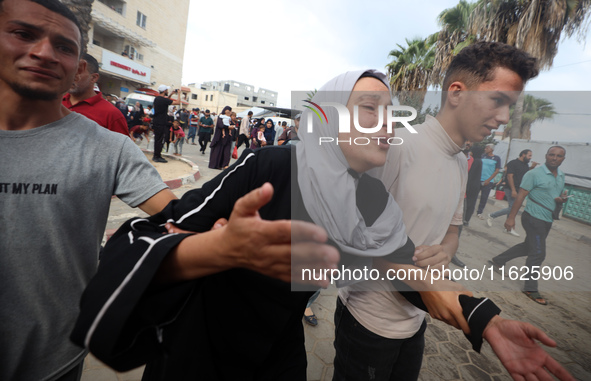 Relatives of Palestinians who are killed following the Israeli attack on the Nuseirat refugee camp mourn after the bodies are transferred to...