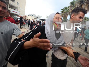 Relatives of Palestinians who are killed following the Israeli attack on the Nuseirat refugee camp mourn after the bodies are transferred to...