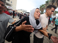 Relatives of Palestinians who are killed following the Israeli attack on the Nuseirat refugee camp mourn after the bodies are transferred to...