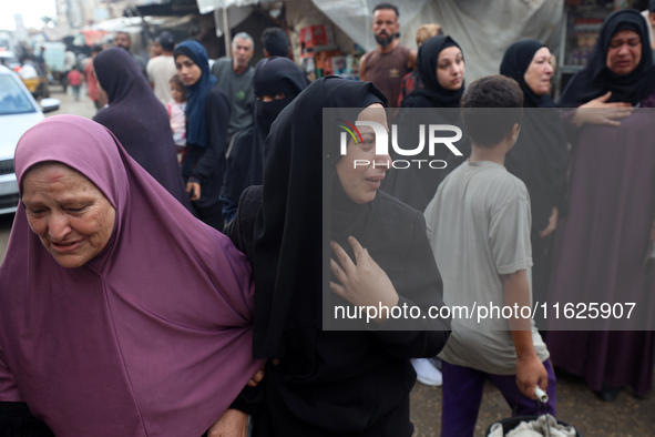 Relatives of Palestinians who are killed following the Israeli attack on the Nuseirat refugee camp mourn after the bodies are transferred to...