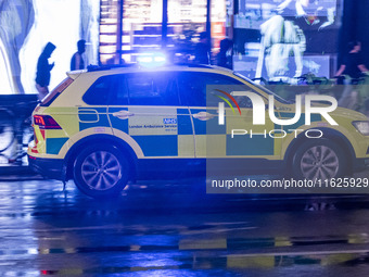 Ambulance in London. Emergency Services Ambulance Vehicle of NHS London Ambulance Service spotted during the night flashing blue light and u...