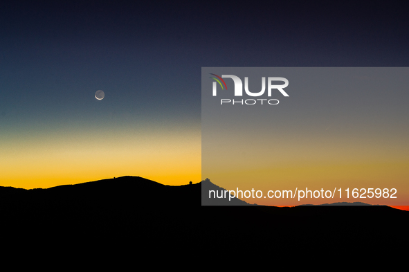 C/2023 A3 (Tsuchinshan-ATLAS) comet and waning moon are seen before sunrise above Rocca Calascio castle and Santa Maria della Pieta church i...