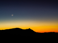 C/2023 A3 (Tsuchinshan-ATLAS) comet and waning moon are seen before sunrise above Rocca Calascio castle and Santa Maria della Pieta church i...