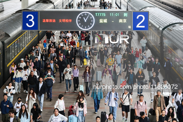 Tourists travel at Nanjing Railway Station in Nanjing, China, on October 1, 2024. 