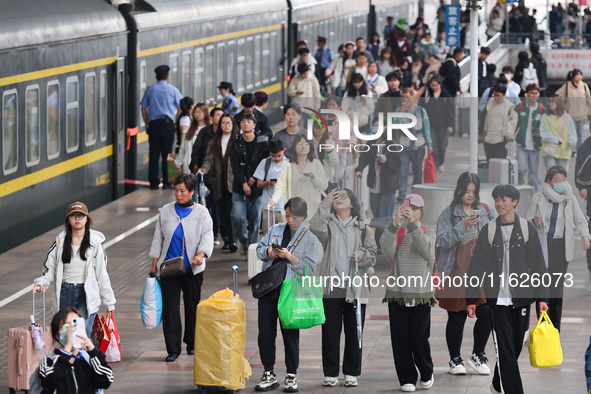 Tourists travel at Nanjing Railway Station in Nanjing, China, on October 1, 2024. 