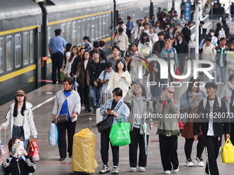 Tourists travel at Nanjing Railway Station in Nanjing, China, on October 1, 2024. (