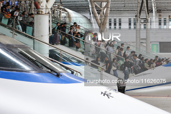 Tourists travel at Nanjing Railway Station in Nanjing, China, on October 1, 2024. 