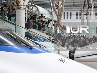 Tourists travel at Nanjing Railway Station in Nanjing, China, on October 1, 2024. (