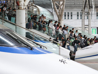 Tourists travel at Nanjing Railway Station in Nanjing, China, on October 1, 2024. (