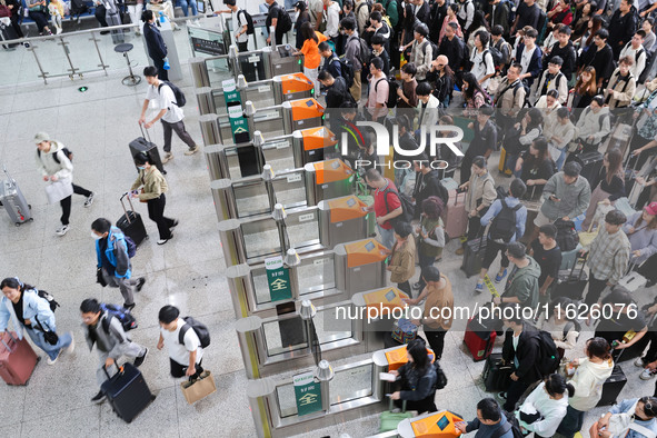 Tourists travel at Nanjing Railway Station in Nanjing, China, on October 1, 2024. 