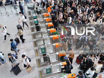 Tourists travel at Nanjing Railway Station in Nanjing, China, on October 1, 2024. (