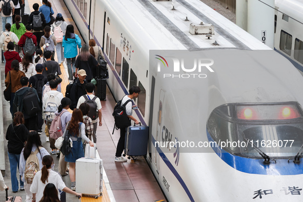 Tourists travel at Nanjing Railway Station in Nanjing, China, on October 1, 2024. 