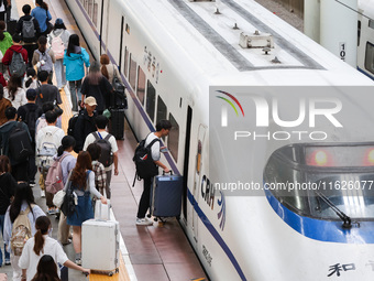 Tourists travel at Nanjing Railway Station in Nanjing, China, on October 1, 2024. (