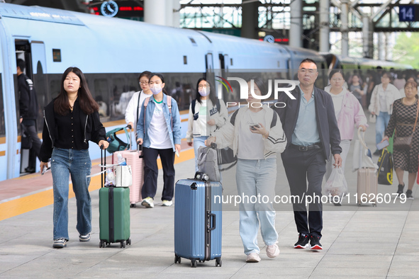 Tourists travel at Nanjing Railway Station in Nanjing, China, on October 1, 2024. 