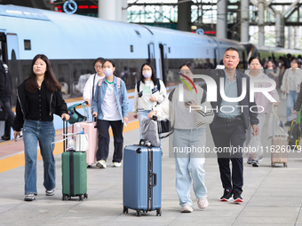 Tourists travel at Nanjing Railway Station in Nanjing, China, on October 1, 2024. (