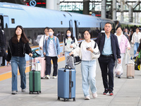 Tourists travel at Nanjing Railway Station in Nanjing, China, on October 1, 2024. (