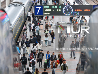 Tourists travel at Nanjing Railway Station in Nanjing, China, on October 1, 2024. (