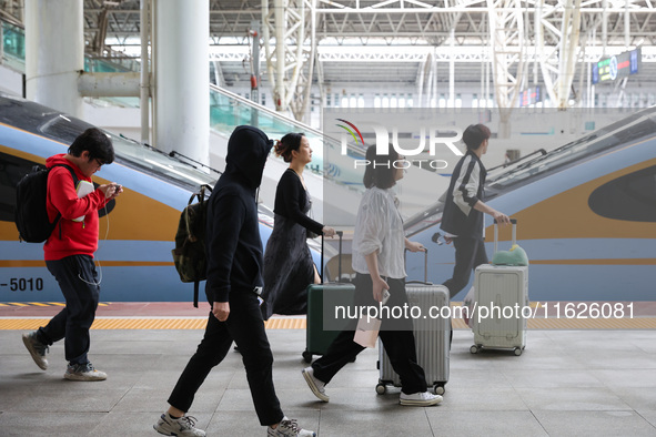 Tourists travel at Nanjing Railway Station in Nanjing, China, on October 1, 2024. 